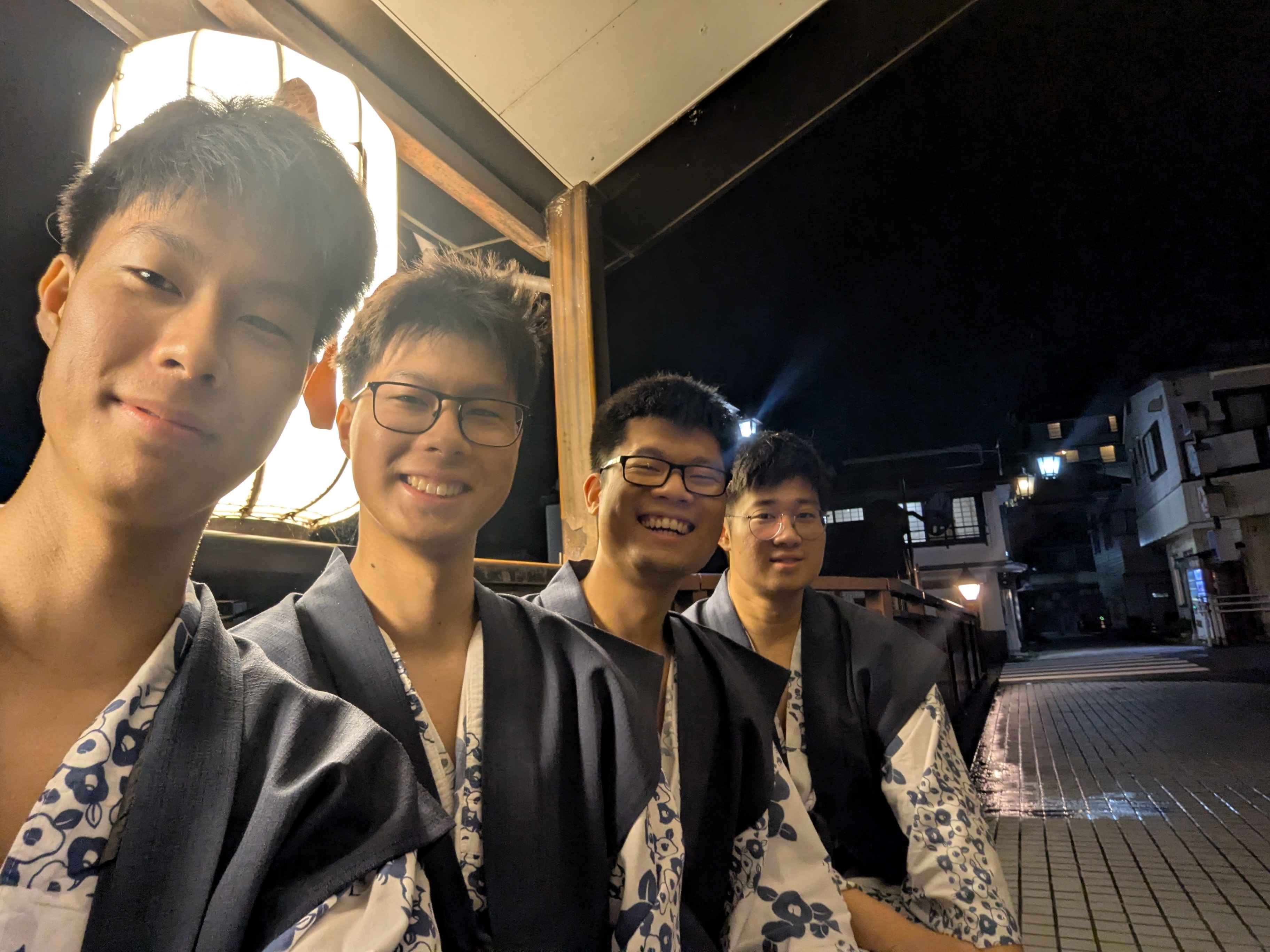 Friends in yukata on a street at night